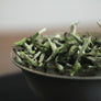 Macro photograph of Silver Needle White Tea buds with silver-white fuzz
