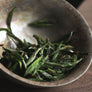 Macro photograph of Silver Needle White Tea buds with silver-white fuzz